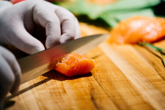 Sushi chef slices salmon