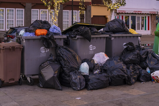 Santa Cruz de La Palma, Canary Islands, Spain - 01 January 2026: View of overflowing trash bins piled up on the sidewalk in front of a restaurant.