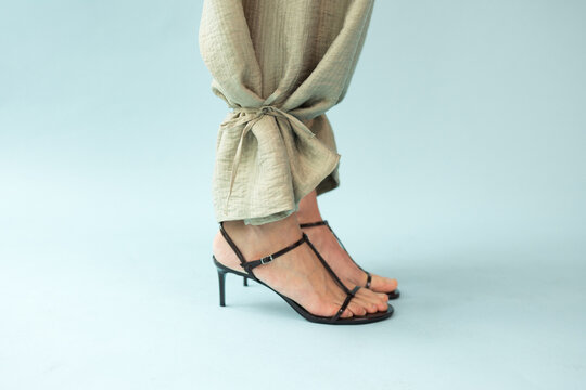 Close Up Detail of Sage Beige Linen Trousers and Black Strappy Sandals