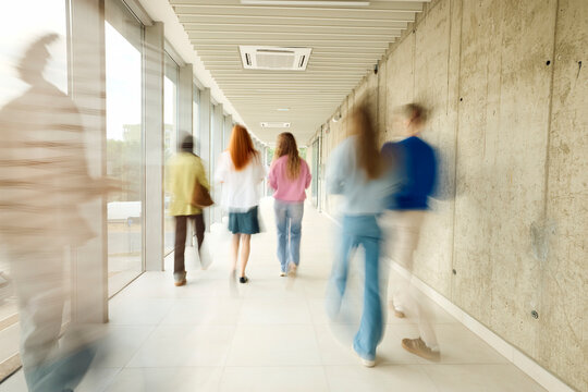 People Walking in a Hallway of a Modern Building