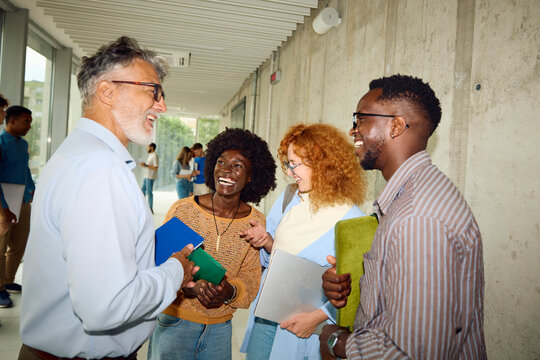 Professor chat his students in a busy hallway
