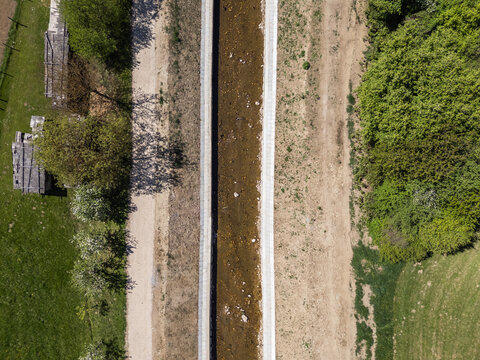Aerial view of river restoration work with channel widening and cleaning for flood protection. The project improves river management.