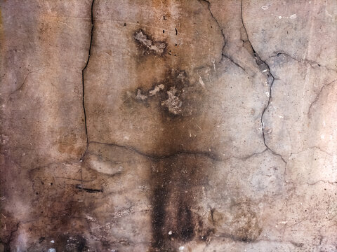 Weathered concrete wall texture with deep cracks and stains.