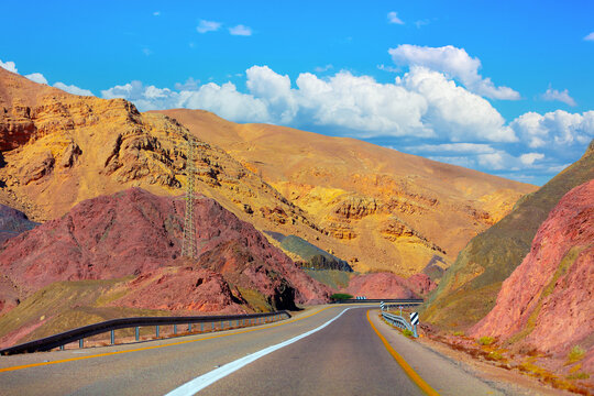 Highway in the mountain desert. Sandstone mountains along the road. View from car