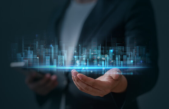 Businessman presenting smart city building hologram. Concept for smart city technology, digital transformation, real estate architecture, future development or Futuristic real estate concept