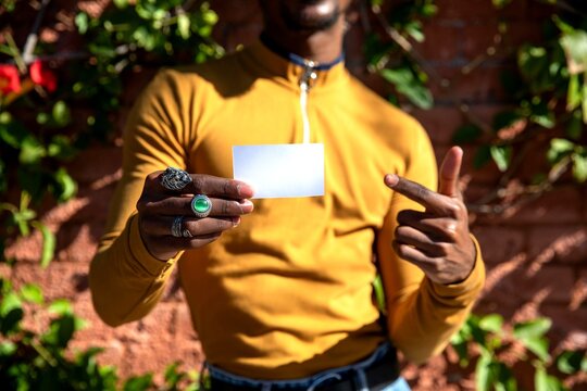 Man holding blank card outdoors.