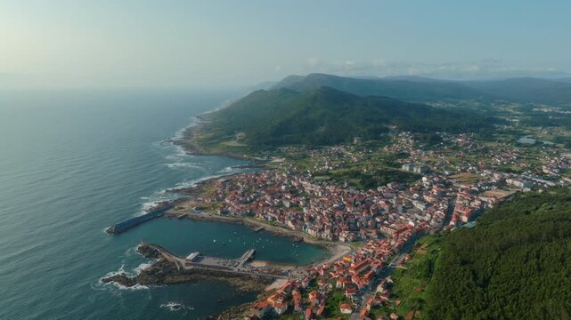 Majestic and expansive aerial vista of A Guarda, Spain, capturing the harmonious embrace between the rugged Atlantic coastline, the tranquil harbor, and the lush, rolling mountains that evoke a deep