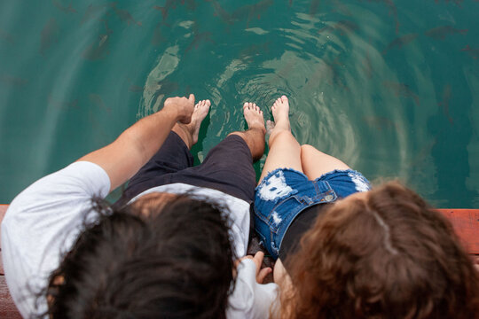 Couple relaxing by serene water.