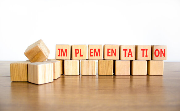 Implementation word symbol. Concept word Implementation on beautiful wooden blocks. Beautiful wooden table white background. Business implementation word concept. Copy space.