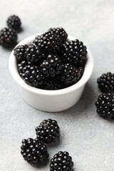 Ripe blackberries in bowl on light grey table, closeup © New Africa