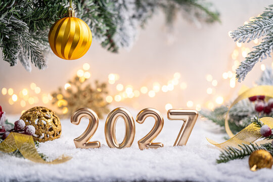 Gold balloons forming 2026 with festive ornaments, frosted pine branches, and sparkling lights in a snowy holiday setting. Winter Christmas Holiday Decoration Background