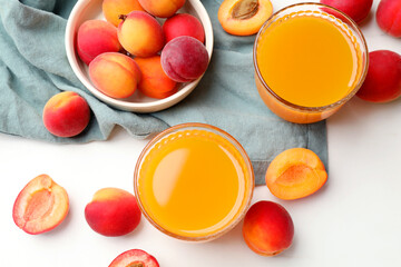 Apricot juice in glasses and fresh fruits on white table, flat lay © New Africa