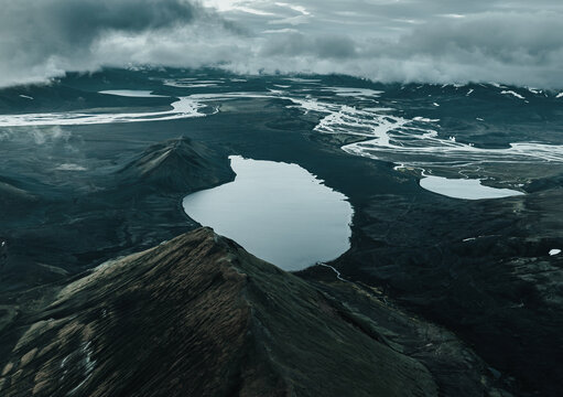 Panoramic view of Lj&oacute;tipollur crater lake in Iceland's Highlands, surrounded by dark volcanic slopes beneath dramatic storm clouds. A remote and breathtaking volcanic landscape.