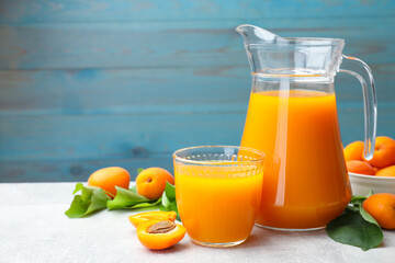 Apricot juice, fresh fruits and leaves on light table, space for text © New Africa