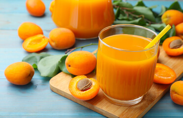 Apricot juice in glass and fresh fruits on light blue wooden table, closeup © New Africa