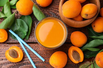 Apricot juice in glass, fresh fruits and drinking straws on wooden table, flat lay © New Africa