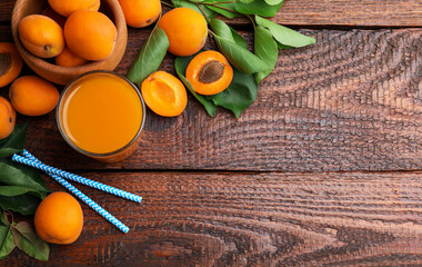 Apricot juice in glass, fresh fruits and drinking straws on wooden table, flat lay. Space for text © New Africa