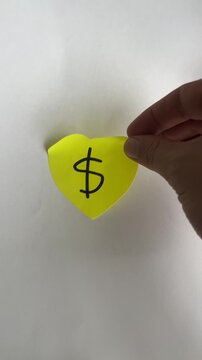 Hand holding heart shaped note with dollar sign love for money. Healthy business