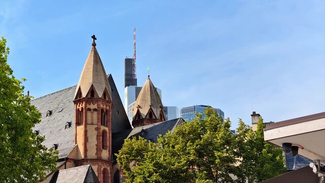 Frankfurt am Main, historic buildings with distinctive towers and traditional roofs stand directly in front of the modern skyscrapers of Frankfurt's financial district