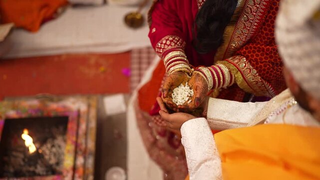 Indian Bride and Groom Holding Grains over Sacred Wedding Fire