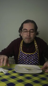 Medium Vertical Shot of Man Finishing Pasta Meal and Leaving Table, Man Eating Last Bite of Fettuccine Wiping Mouth and Standing Up