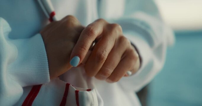 Close up of female hands nervously fidgeting and rubbing together in cozy sweatshirt