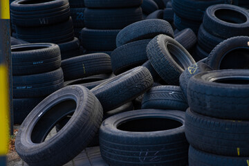 Stack of old used car tires in recycling yard. © TetianaRUD