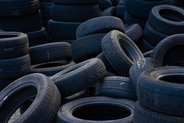 Stack of old used car tires in recycling yard. © TetianaRUD