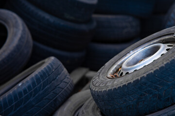 Stack of old used car tires in recycling yard. © TetianaRUD