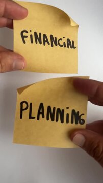 Hand holding sticky notes with financial planning handwritten text