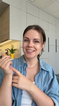Happy smiling woman with wide open eyes nodding in agreement and pointing at viewer, vertical UGC video