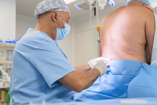 Medical professional giving spinal anesthesia in operating room
