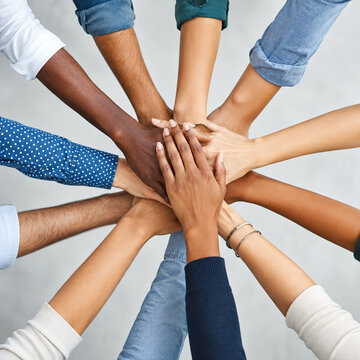 Diverse Team Joining Hands for Workplace Unity and Collaboration