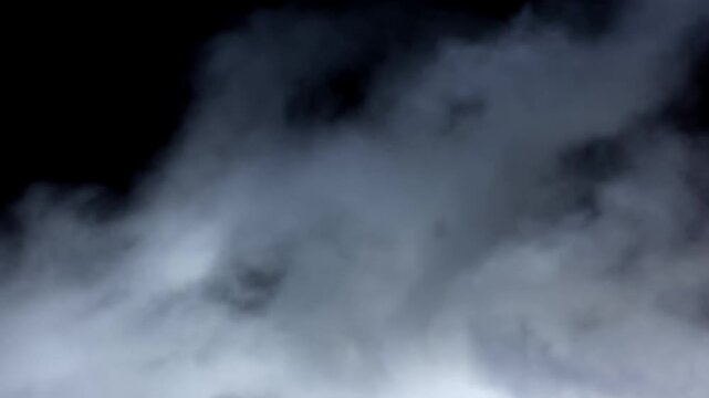Dark storm clouds drifting and billowing across an overcast sky with changing light