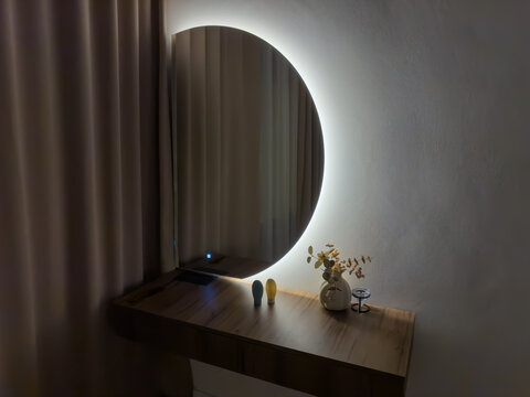 Mirror with electric backlight above dressing table in on state