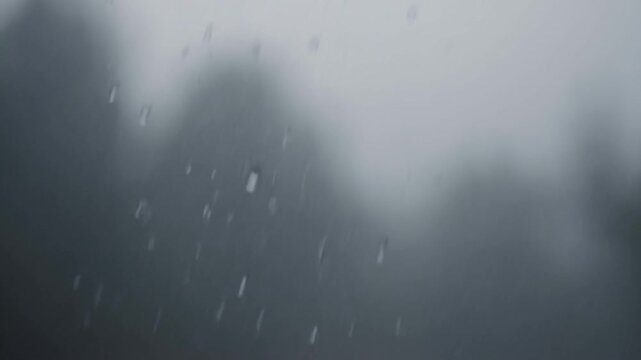 Water droplets on foggy glass form a soft gray window surface in diffuse light