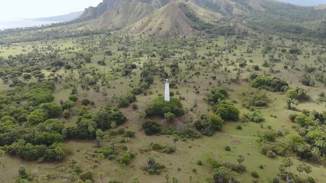 Aerial view of Nuca Molas peak rising above lush green hills and tropical vegetation in Satar Mese Barat, East Nusa Tenggara, Indonesia.