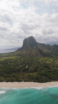 Aerial view of Nuca Molas peak rising above lush green hills and tropical vegetation in Satar Mese Barat, East Nusa Tenggara, Indonesia.