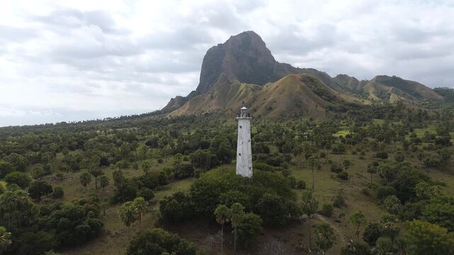 Aerial view of Nuca Molas peak rising above lush green hills and tropical vegetation in Satar Mese Barat, East Nusa Tenggara, Indonesia.