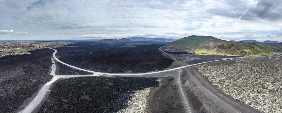 Aerial view of volcanic lava fields and winding roads cutting through the rugged terrain in Grindavik, Reykjanes Peninsula, Iceland.