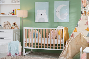 Cute baby room interior with comfortable crib, wigwam and other toys © New Africa