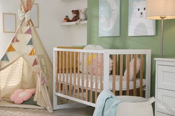 Cute baby room with comfortable crib, wigwam and other toys. Interior design © New Africa