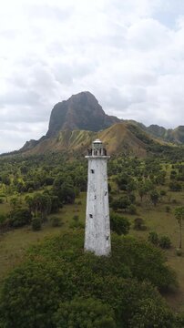 Aerial view of Nuca Molas peak rising above lush green hills and tropical vegetation in Satar Mese Barat, East Nusa Tenggara, Indonesia.