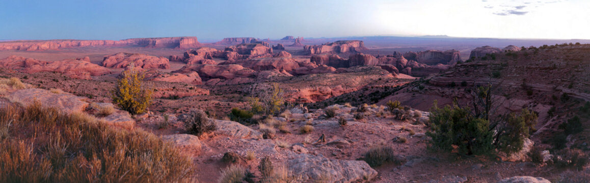 Beautiful wide panoramic view of giant sandstone canyon rock formations in desert at sunrise