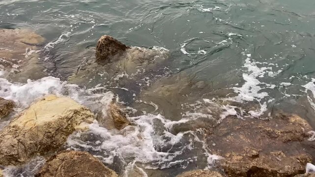 A gentle rise of water among coastal rocks due to a meteorological tsunami. Speed ​​0.9x. Mallorca, Spain.