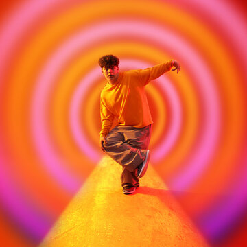 Young hip-hop dancer posing against bright colorful background. Creative poster