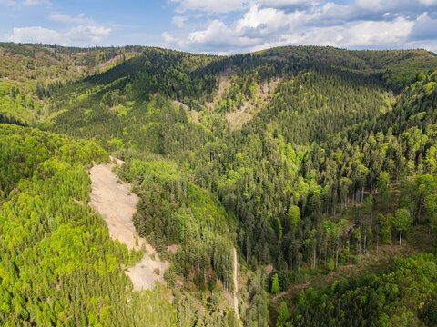 Aerial view of Svatodusna Old copper mine dumps surrounded by dense green forests and rolling hills in Lubietova, Banska Bystrica Region, Slovakia.