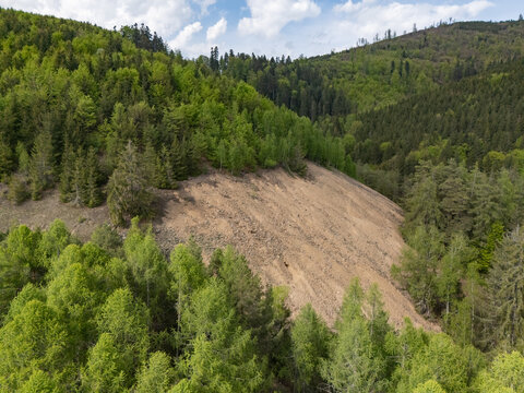 Aerial view of Svatodusna Old copper mine dumps surrounded by lush green forests and rocky slopes in Lubietova, Banska Bystrica Region, Slovakia.