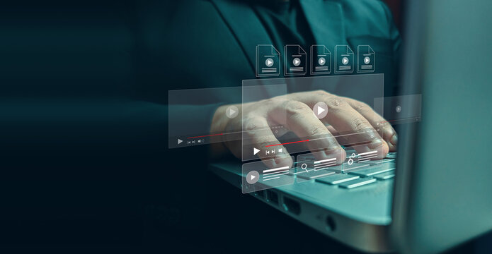 Person typing on a laptop with digital video interface overlays in a dark office environment with while interacting holographic interface elements floating floating above keyboard person uses data