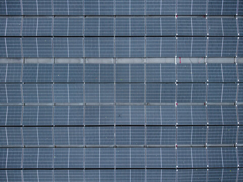 Aerial view of solar panels installed on a rooftop under overcast skies in Riga, Latvia.
